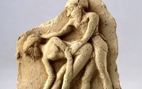 A sculpture depicting two figures engaged in a dynamic pose.